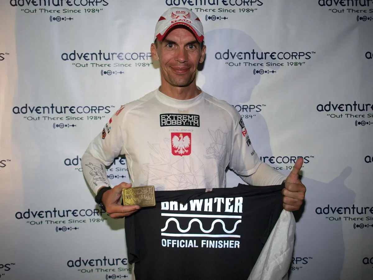 Artur Kujawiński z klamrą i koszulką Badwater Official Finisher